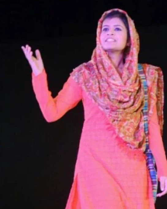 Ira performing on stage in a pink salwar kameez and patterned dupatta