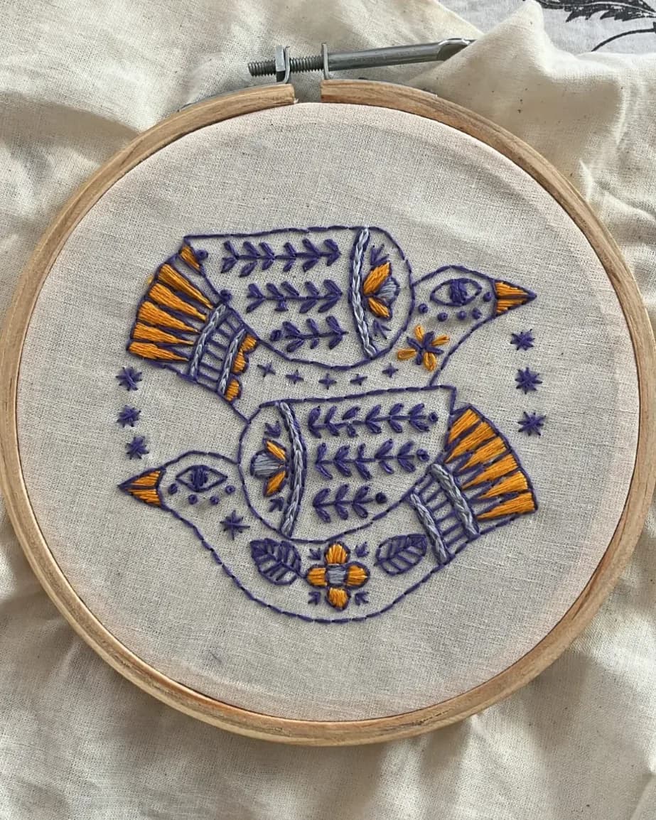 Ira's hand embroidery of two folk-art birds in a hoop